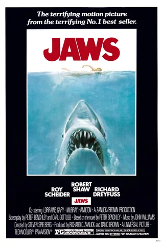 Theatrical poster for Jaws (1975) showing a lone swimmer above and a great white shark approaching from below.